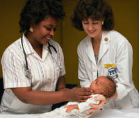 Fotografía de dos enfermeras examinando a un recién nacido